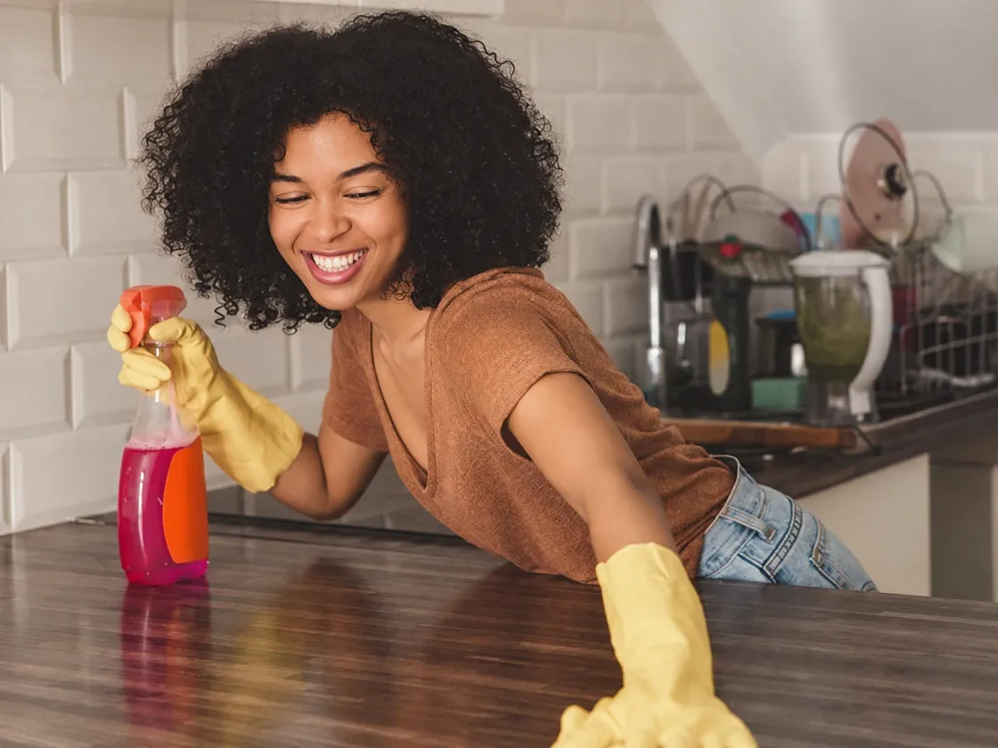Someone in rubber gloves cleaning a kitchen counter