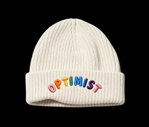 Un bonnet crème brodé du mot « Optimist »