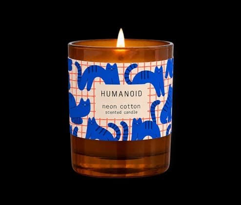 Une bougie en verre ambré avec une étiquette à motifs bleus